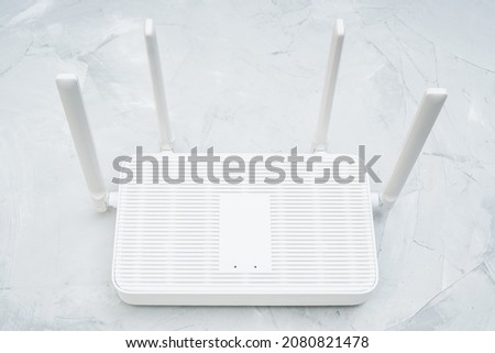 Top view of a dual band wi-fi 6 router with four antennas placed on a concrete table