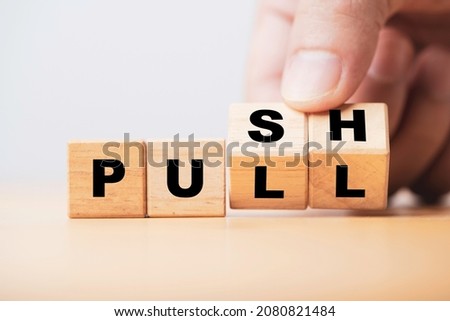 Hand flipping wooden cube block to change push and pull for business strategy and customer marketing concept. Royalty-Free Stock Photo #2080821484