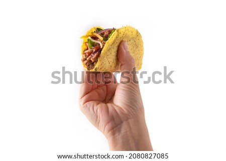 Hand holding traditional Mexican tacos with meat and vegetables isolated on white background