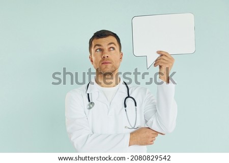 Young doctor. Man standing in the studio with empty signs for the text.