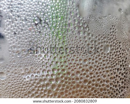 A close-up photo of the condensation of dewdrops on the outside of the glass