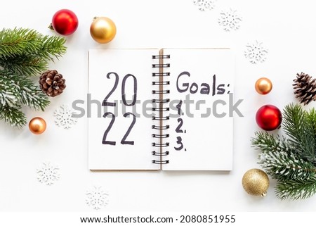 Goals 2022 - New Year plan, text in notebook. Top view, flat lay