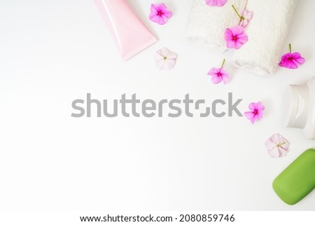 Delicate background, intimate hygiene gel, white towels and a container with pink flowers for aromatherapy. Royalty-Free Stock Photo #2080859746