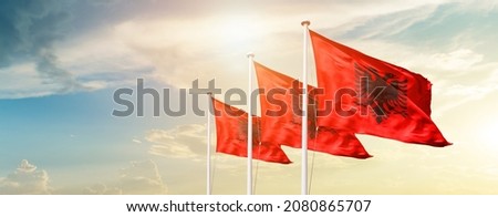 Flag of Albania wave wind. Backdrop on beautiful sky.