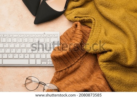 Computer keyboard, clothes and eyeglasses on color background
