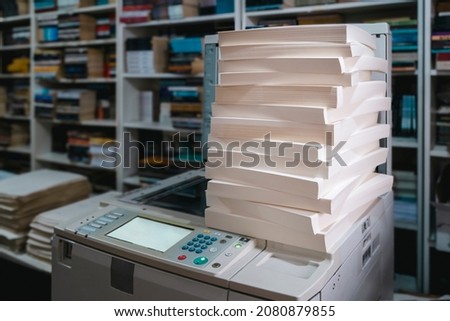 stacks of papers on the printing press at the publishing house