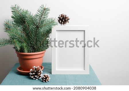 Christmas frame mockup with fir tree branches with cones in terracotta pot