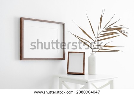 Landscape and portrait frames mockup with copy space for artwork, photo or print presentation. White wall minimalist interior design.