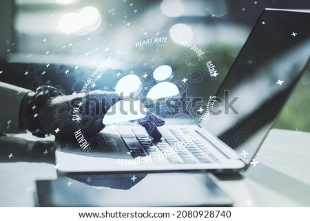 Creative concept of people icons and hands typing on laptop on background. Life and health insurance concept. Multiexposure