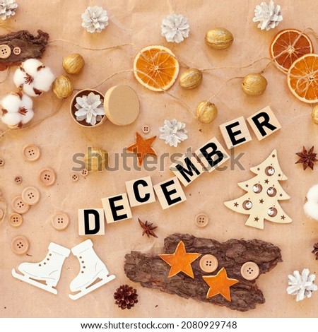DECEMBER. text on wooden cubes near new year decoration no waste dried orange wooden skates buttons wood