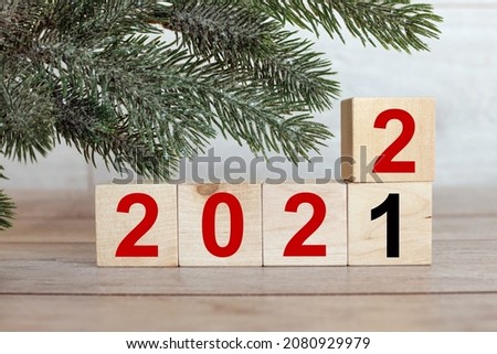 Merry Christmas and Happy New Year text 2021 to 2022. on blocks of wood in red and black numbers,