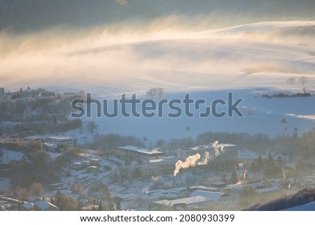 Morning fog over sleepy town that wakes up to a cold and snowy morning,a city in the valley above which the hills rise,Slovakia