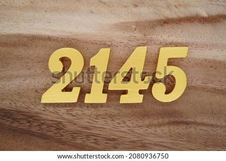 Golden Arabic numerals 2145 on a dark brown to white wood grain background.