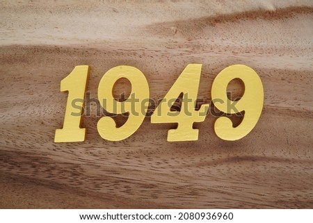 Golden Arabic numerals 1949 on a dark brown to white wood grain background.