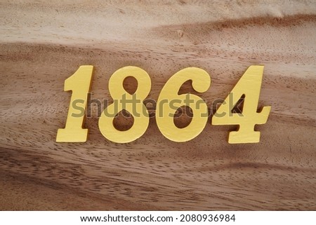 Golden Arabic numerals 1864 on a dark brown to white wood grain background.