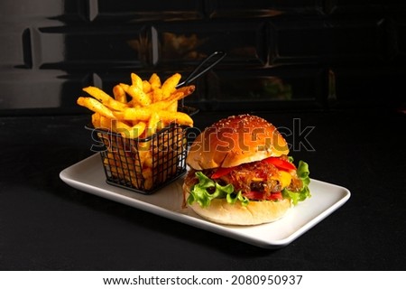 
big tasty steak burger with serving plate on black background