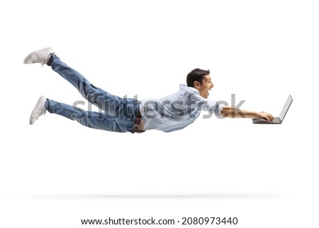 Young casual man flying and working on a laptop computer isolated on white background Royalty-Free Stock Photo #2080973440
