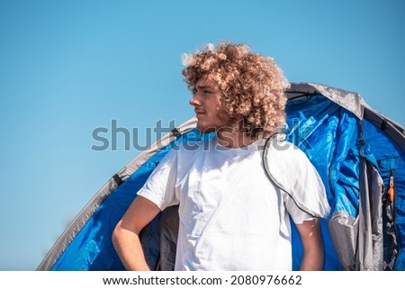 a teenager comes out of a mountain tent after a sleepless night. High quality photo