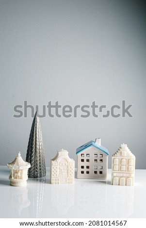 Happy holidays. Christmas little house with golden lights bokeh and tree on white background. Festive modern decor. Miniature cozy home. Merry Christmas