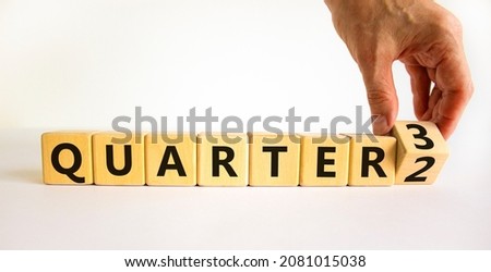 From 2nd to 3rd quarter symbol. Businessman turns a cube and changes words 'quarter 2' to 'quarter 3'. Beautiful white table, white background. Business, happy 3rd quarter concept, copy space.
