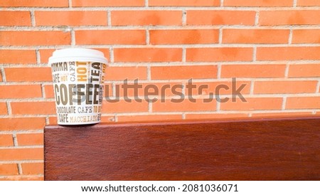 cardboard cup of coffee to go on a bench table with the name of different types of coffee in different languages