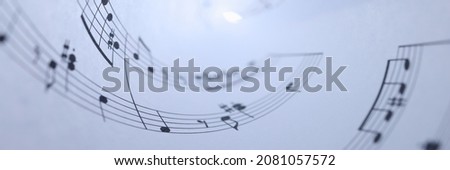 White paper with musical notes rolled up closeup background. Music writing concept Royalty-Free Stock Photo #2081057572