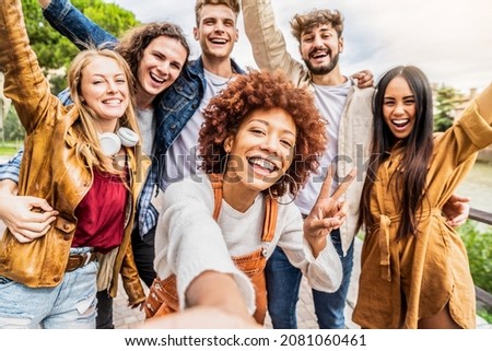 Multicultural best friends having fun taking group selfie portrait outside - Smiling guys and girls celebrating party day hanging out together on city street - Happy lifestyle and friendship concept Royalty-Free Stock Photo #2081060461