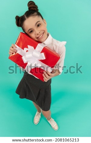 positive teen girl in school uniform with box. boxing day. present and gifts buy.