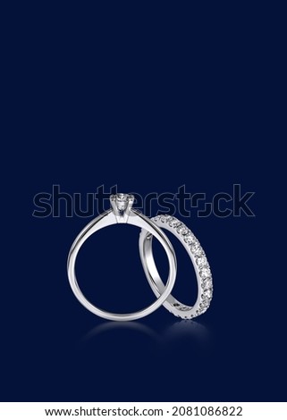 Diamond wedding set, solitaire engagement ring, eternity bands on navy blue background
