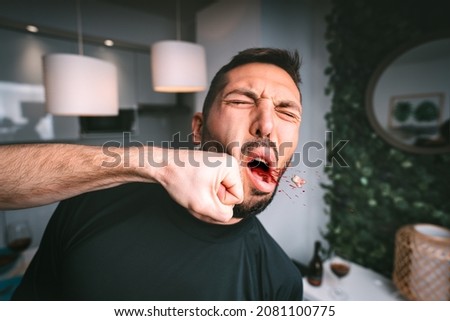 Man takes hard punch in the face. Two man fighting. Man hitting beaten man in the face with fist. Conflict and violence concept Royalty-Free Stock Photo #2081100775