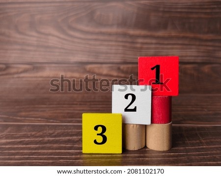 Colored wooden cube with counting number 321 on a wooden background.