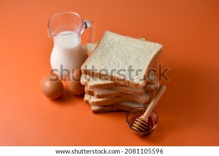 Sliced Toast Loaf White Bread (Shokupan or Roti Tawar) for Breakfast on light background. Served with honey, milk and egg, with Bakery Concept Picture. Copy Space for Text