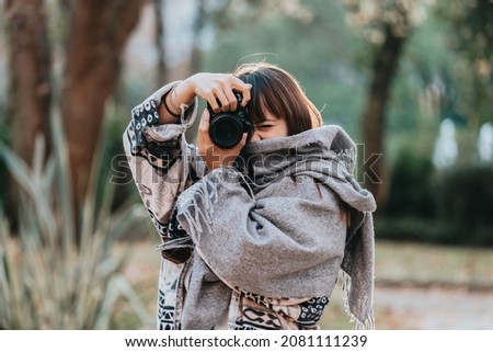 Portrait of beautiful spanish woman photographer with digital camera. holding professional camera. amazing red hair posing outdoors holding camera, redhead woman is relaxing on the park. smile camera