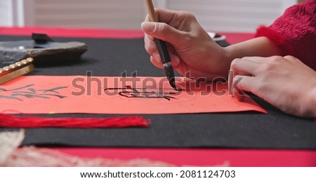 Close up of writing spring festival couplets to celebrate Chinese new year with word meaning wishing you prosperity and wealth Royalty-Free Stock Photo #2081124703