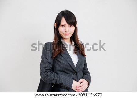 Asian business woman wearing a suit and holding a work bag