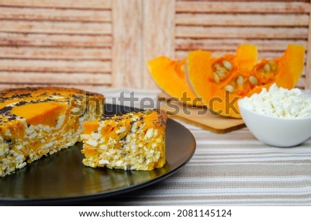 Pumpkin casserole with cottage cheese and poppy seeds on a background of ingredients. Rustic still life. Pumpkin curd pie, pumpkin slices and homemade cottage cheese in a white bowl.
