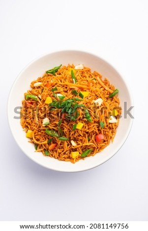 Schezwan Fried Rice Masala or szechuan rice is a popular indo-chinese food served in a plate or bowl with chopsticks. selective focus Royalty-Free Stock Photo #2081149756