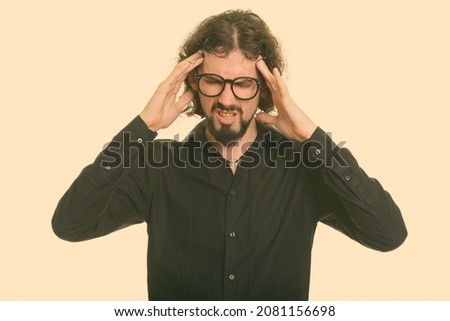 Studio shot of handsome bearded businessman with curly hair isolated against white background