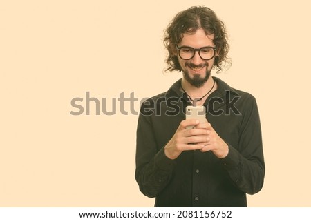 Studio shot of handsome bearded businessman with curly hair isolated against white background
