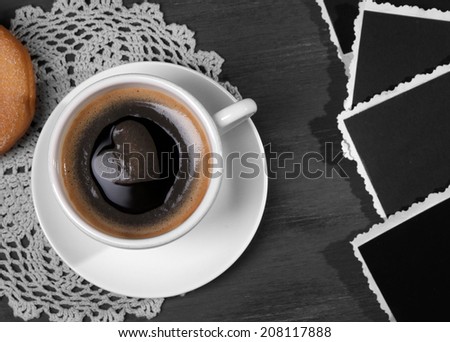 Coffee cup, donut and old blank photos, on wooden table