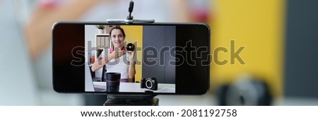 Woman blogger conducts review of photographic equipment and lenses for high-quality shooting. Choosing a camera for video shooting concept