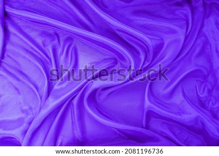 The texture of flowing lavender satin fabric. free space for your text. Canvas texture or background.
