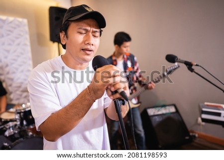 a vocalist enjoys music while singing with a band