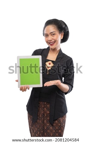 happy asian woman with kebaya showing tablet screen