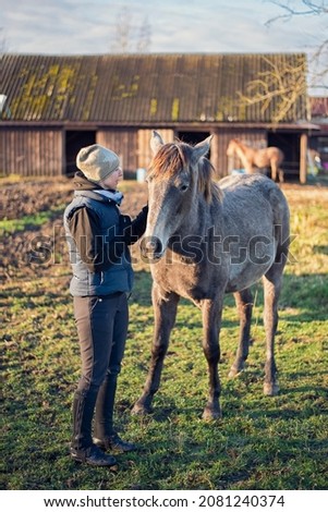 girl in stables with horse