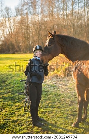 happy girl with a horse after riding lesson