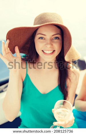 summer holidays, vacation and celebration concept - smiling girl in hat with champagne glass