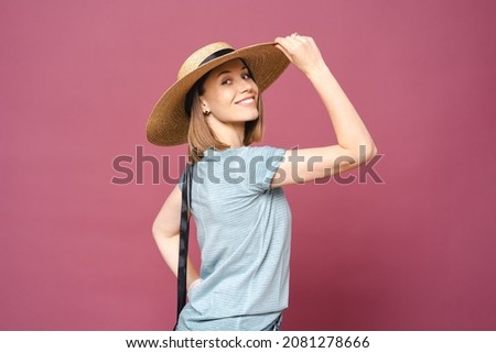 Portrait of beautiful young woman in casual wearing straw hat on pink background. Cheerful young woman smiling during summer vacation.