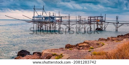 Exotic old wooden fishing pier on popular tourist attraction - Trabocco Turchino. Picturesque morning seascape of Adriatic sea, Italy, Europe. Traveling concept background.