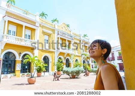 Side view of woman traveling in Cartagena de Indias. Horizontal view of latin woman sightseeing in spanish historic ancient city. Travel to Colombia concept. Royalty-Free Stock Photo #2081288002